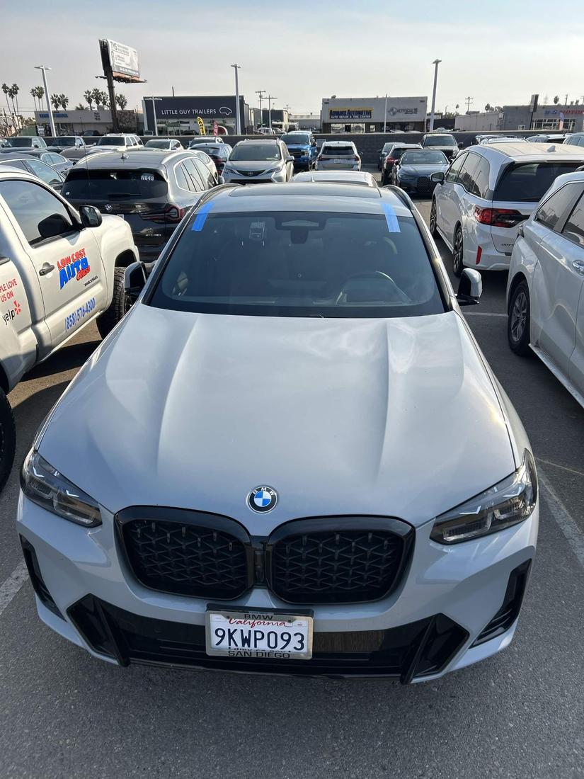BMW with a newly installed windshield, alignment tape still in place while it cures